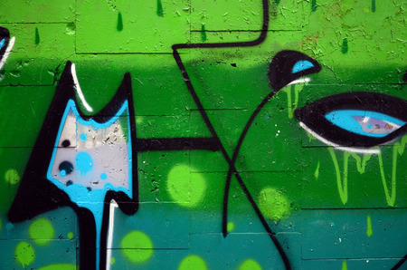 A fragment of graffiti drawing using contours, applied to the wall with the help of cans with aerosol paints over the colored filling areas. Background texture of street art and vandalismのeditorial素材