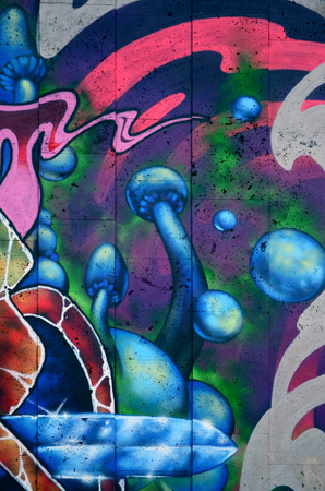 A fragment of detailed graffiti of a drawing made with aerosol paints on a wall of concrete tiles. Background image of street art with fairy blue mushroomsの写真素材