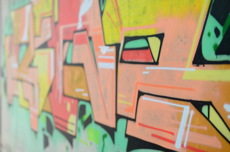 Background image with a colored graffiti pattern, which is applied to the concrete wall with aerosol paints. A lot of contours and fragments filled with paint, forming an interesting compositionの写真素材