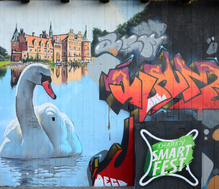 A fragment of detailed graffiti of a drawing made with aerosol paints on a wall of concrete tiles. Background image of street art with a huge white swanの写真素材