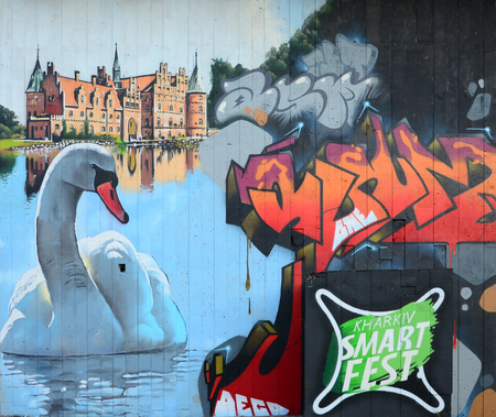 A fragment of detailed graffiti of a drawing made with aerosol paints on a wall of concrete tiles. Background image of street art with a huge white swanの写真素材