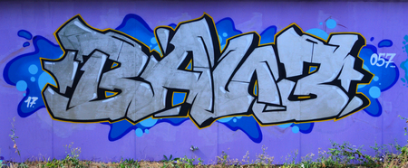 The old wall, painted in color graffiti drawing silver chrome aerosol paints. Background image on the theme of drawing graffiti and street artの写真素材