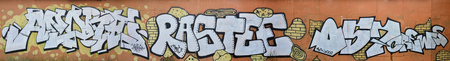 A photo of several graffiti artworks on the metal wall. Graffiti drawings are made with white paint with black outlines and have an orange background. Texture of wall with graffiti decorationの写真素材