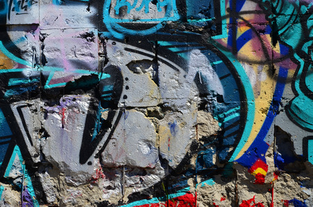 Fragment of an old colored graffiti drawing on the wall. Background image as an illustration of street art, vandalism and wall painting with aerosol paintの写真素材