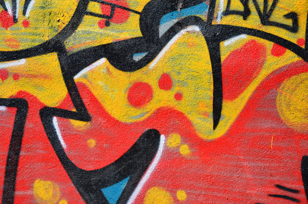 Fragment of an old colored graffiti drawing on the wall. Background image as an illustration of street art, vandalism and wall painting with aerosol paintの写真素材