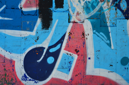 Fragment of an old colored graffiti drawing on the wall. Background image as an illustration of street art, vandalism and wall painting with aerosol paintの写真素材