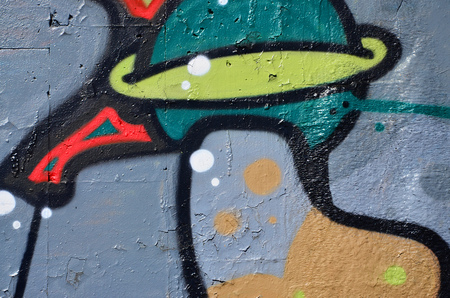 Fragment of an old colored graffiti drawing on the wall. Background image as an illustration of street art, vandalism and wall painting with aerosol paintの写真素材