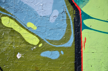 Fragment of an old colored graffiti drawing on the wall. Background image as an illustration of street art, vandalism and wall painting with aerosol paintの写真素材