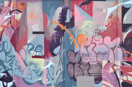 Multicolored graffiti on an old concrete wall. A beautiful form of vandalism in urban conditions. Different lines and shapes, painted with cans of paint for graffiti. Youth contemporary artの写真素材