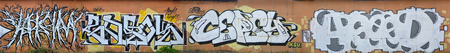 A photo of several graffiti artworks on the metal wall. Graffiti drawings are made with white paint with black outlines and have an orange background. Texture of wall with graffiti decorationの写真素材