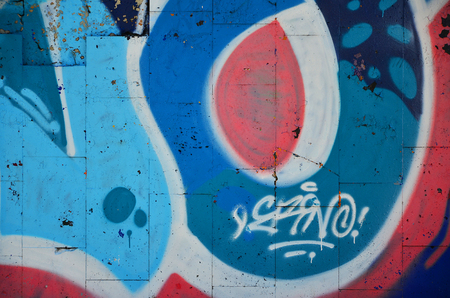 Fragment of an old colored graffiti drawing on the wall. Background image as an illustration of street art, vandalism and wall painting with aerosol paintの写真素材
