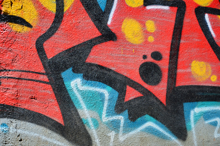 Fragment of an old colored graffiti drawing on the wall. Background image as an illustration of street art, vandalism and wall painting with aerosol paintの写真素材