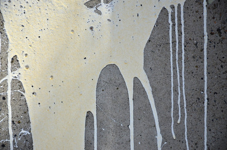 A photograph of a close-up of black paint spots on a concrete wall. Pouring paint on the wall in random order. The concept of graffiti and street art cultureの写真素材