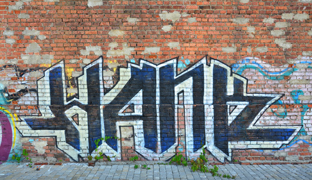 Texture of a fragment of the wall with graffiti painting, which is depicted on it. An image of a piece of graffiti drawing as a photo on street art and graffiti culture topicsの写真素材