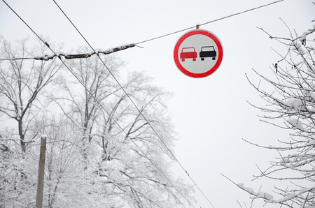 Road sign. Overtaking is prohibited. The sign prohibits overtaking all vehicles on the road section. A red and black car is depicted in a framed red circleの写真素材