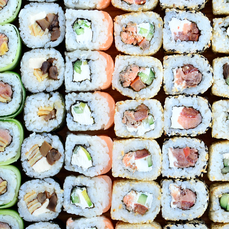 Close-up of a lot of sushi rolls with different fillings. Macro shot of cooked classic Japanese food. Background imageの写真素材