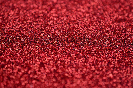 A huge amount of red decorative sequins. Background texture with shiny, small elements that reflect light in a random order. Glitter textureの写真素材