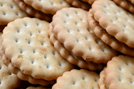Detailed picture of round sandwich cookies with coconut filling. Background image of a close-up of several treats for teaの写真素材