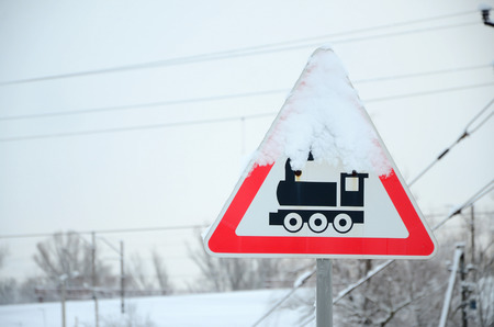 Railway crossing without barrier. A road sign depicting an old black locomotive, located in a red triangleの写真素材