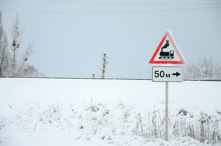 Railway crossing without barrier. A road sign depicting an old black locomotive, located in a red triangleの写真素材