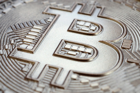 Close up shot of a physical bitcoin with a shiny relief surface made of chocolate. Abstract image of the crypto currency in an edible formの写真素材