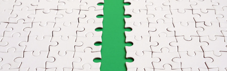The green path is laid on the platform of a white folded jigsaw puzzle. Texture image with copy space for textの写真素材