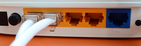 The Internet cable plugs are connected to the Internet router, which lies on a bright orange...