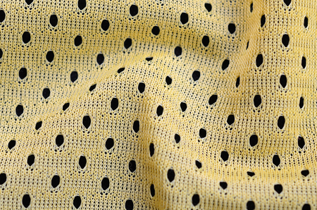 Yellow sport jersey clothing fabric texture and background with many foldsの写真素材