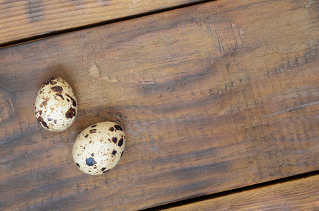 Quail eggs on a dark brown wooden surface, top view, empty place for text, recipeの写真素材