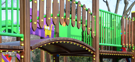 Fragment of a playground made of plastic and wood, painted in different colors