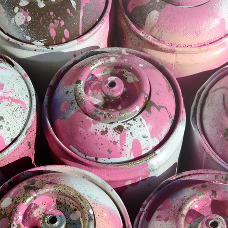 A lot of used pink metal tanks with paint for drawing graffitiの写真素材