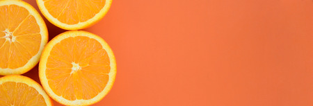 Top view of a several orange fruit slices on bright background in orange color. A saturated citrus texture imageの写真素材