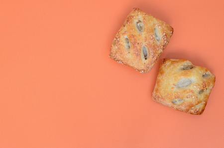 A satisfying meat patty, which combines an airy puff pastry and a delicate pork filling with onions. Baking on an orange backgroundの写真素材