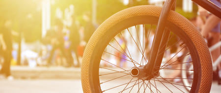 A bike wheel against the backdrop of a blurred street with cycling riders. Extreme Sports Conceptの写真素材