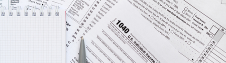 The pen and notebook is lies on the tax form 1040 U.S. Individual Income Tax Return. The time to pay taxesの写真素材