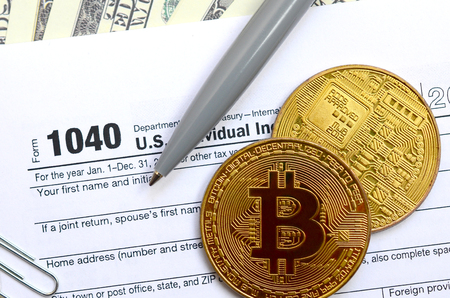 The pen, bitcoins and dollar bills is lies on the tax form 1040 U.S. Individual Income Tax Return. The time to pay taxesの写真素材