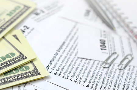 The pen, notebook and dollar bills is lies on the tax form 1040 U.S. Individual Income Tax Return. The time to pay taxesの写真素材