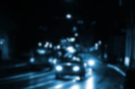 Blurred night scene of traffic on the roadway. Defocused image of cars traveling with luminous headlights. Bokeh Artの写真素材