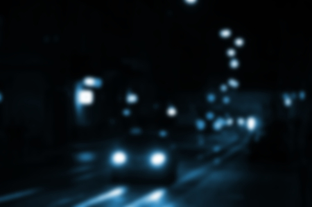 Blurred night scene of traffic on the roadway. Defocused image of cars traveling with luminous headlights. Bokeh Artの写真素材