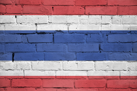 Thailand flag is painted onto an old brick wallの写真素材
