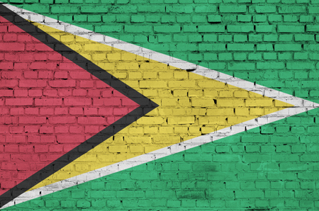 Guyana flag is painted onto an old brick wallの写真素材