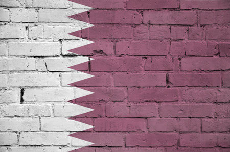 Qatar flag is painted onto an old brick wallの写真素材
