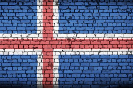 Iceland flag is painted onto an old brick wallの写真素材