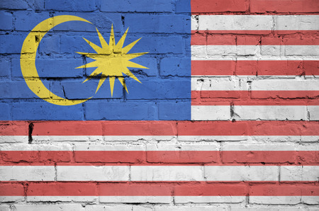 Malaysia flag is painted onto an old brick wallの写真素材