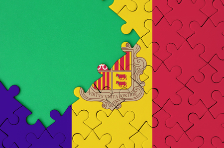 Andorra flag  is depicted on a completed jigsaw puzzle with free green copy space on the left side.の写真素材