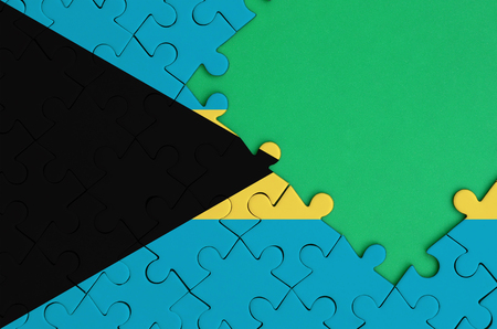 Bahamas flag  is depicted on a completed jigsaw puzzle with free green copy space on the right side.の写真素材