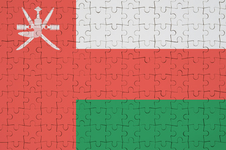 Oman flag  is depicted on a folded puzzleの写真素材