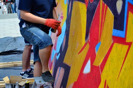 KHARKOV, UKRAINE - MAY 27, 2017: Festival of street arts. Young guys draw graffiti on portable wooden walls in the center of the city. The process of painting on walls with aerosol spray cansのeditorial素材