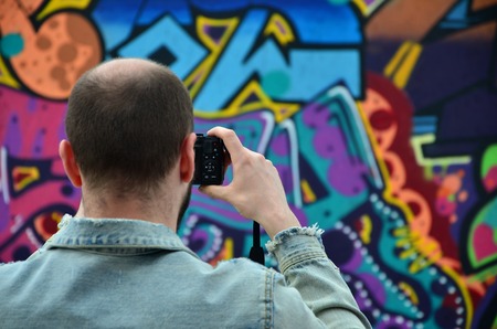 KHARKOV, UKRAINE - MAY 27, 2017: Festival of street arts. Young guys draw graffiti on portable wooden walls in the center of the city. The process of painting on walls with aerosol spray cansのeditorial素材