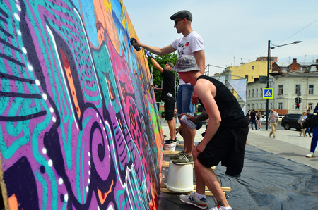 KHARKOV, UKRAINE - MAY 27, 2017: Festival of street arts. Young guys draw graffiti on portable wooden walls in the center of the city. The process of painting on walls with aerosol spray cansのeditorial素材